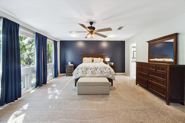 bedroom with baseboards, visible vents, light colored carpet, and ceiling fan
