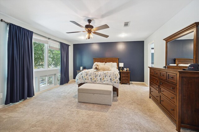 bedroom featuring light carpet, a ceiling fan, visible vents, and baseboards
