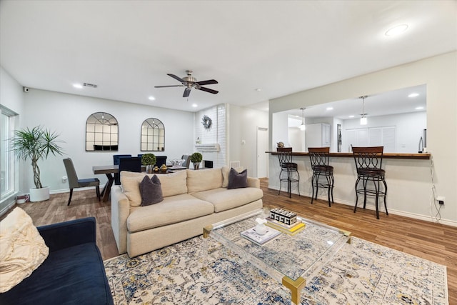 living area with recessed lighting, wood finished floors, visible vents, baseboards, and ceiling fan