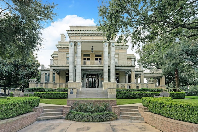 greek revival inspired property with brick siding and a balcony