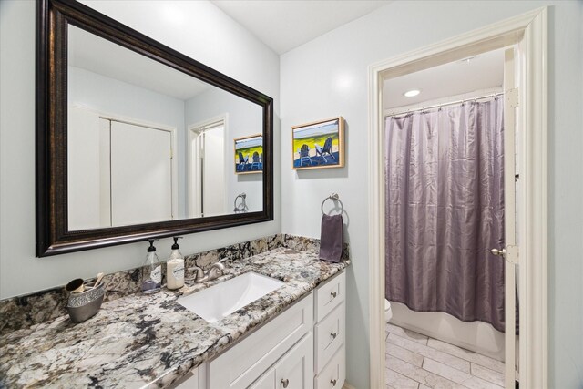 full bath featuring toilet, vanity, and shower / bath combo with shower curtain