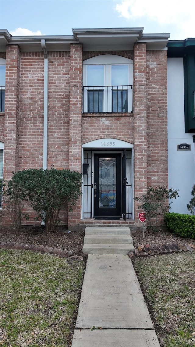 entrance to property featuring brick siding