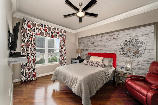 bedroom featuring an accent wall, baseboards, crown molding, and wood finished floors