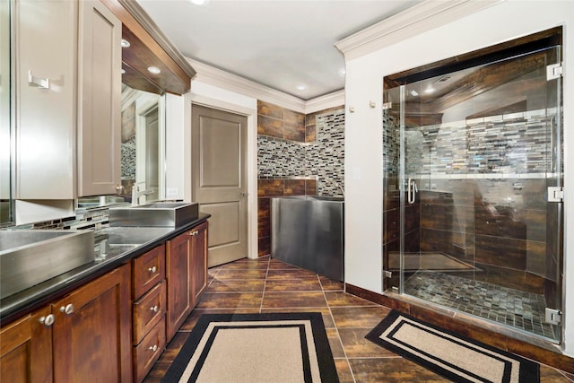 bathroom with recessed lighting, double vanity, ornamental molding, a sink, and a stall shower