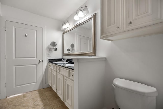 bathroom with double vanity, toilet, and a sink