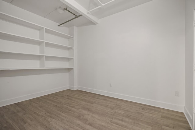 spare room featuring wood finished floors and baseboards