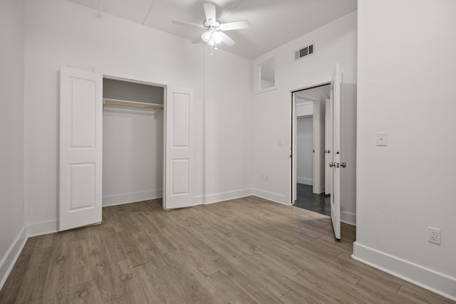 unfurnished bedroom with wood finished floors, visible vents, a ceiling fan, a closet, and baseboards