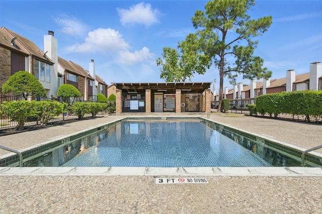 community pool featuring fence and a residential view