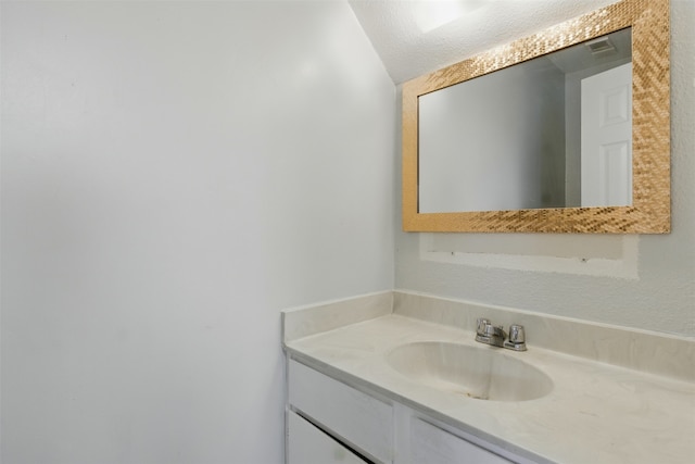 bathroom with a textured ceiling and vanity
