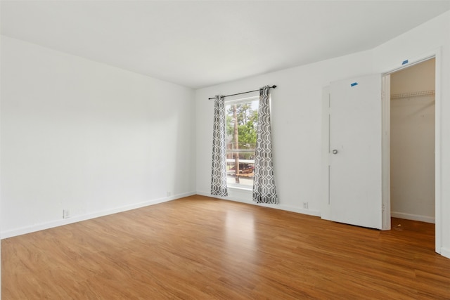 unfurnished room featuring baseboards and light wood-style floors