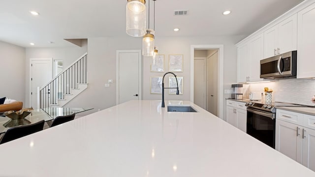 kitchen featuring a sink, visible vents, stainless steel appliances, recessed lighting, and backsplash