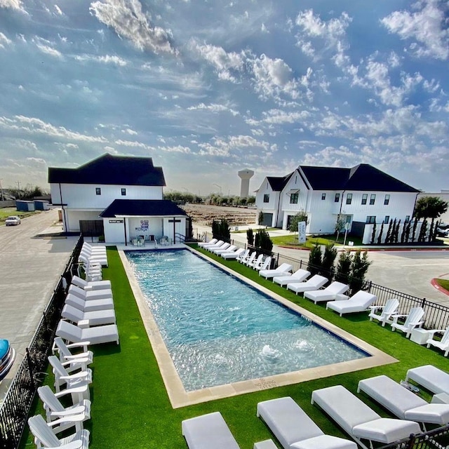 pool featuring fence, a patio area, and an outbuilding