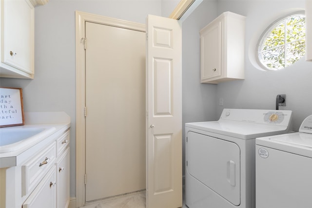 washroom with cabinet space, marble finish floor, a sink, and washer and clothes dryer
