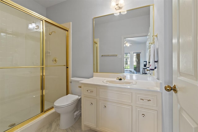 bathroom featuring marble finish floor, toilet, vanity, and a stall shower