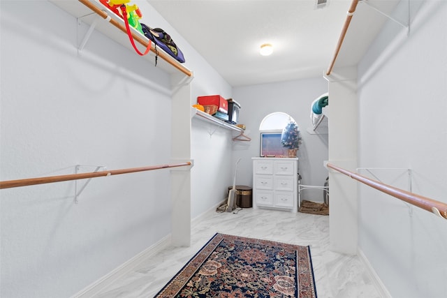 walk in closet with marble finish floor and visible vents