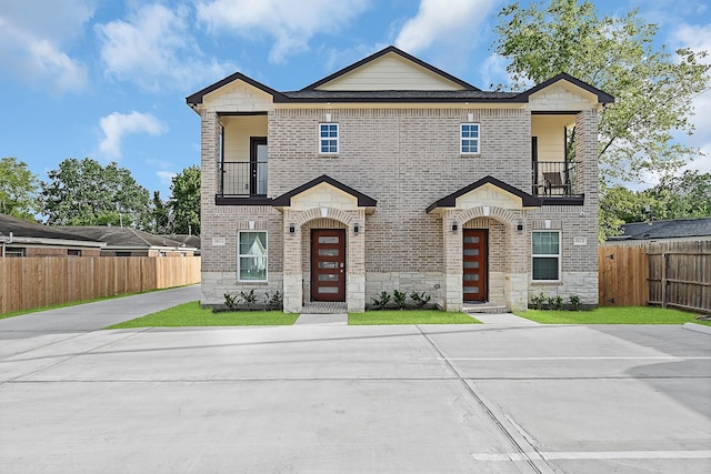4903 Mallow St Unit Ab, Houston, TX 77033 - view of front facade with brick siding, fence, stone siding, and a balcony