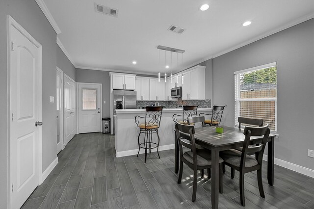 4903 Mallow St Unit Ab, Houston, TX 77033 - dining space with baseboards, crown molding, visible vents, and recessed lighting