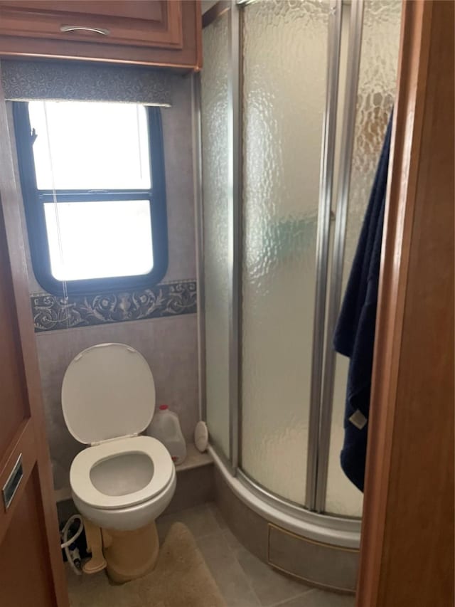 full bath with tile patterned floors, toilet, and a stall shower