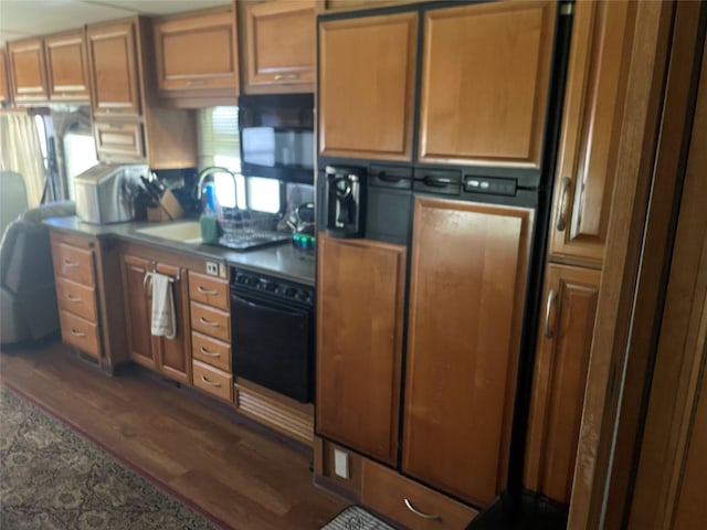 kitchen with black appliances, a sink, and dark wood-type flooring