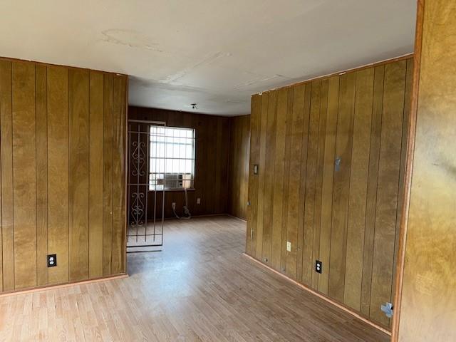 empty room with wooden walls and wood finished floors