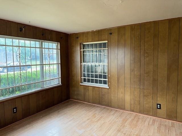empty room featuring wood walls and wood finished floors