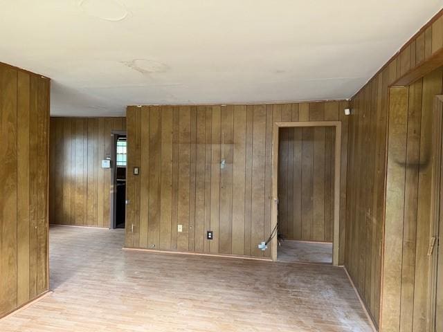 spare room featuring wooden walls and wood finished floors
