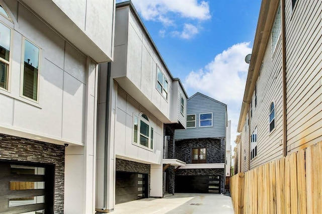1217 Edwards St, Houston, TX 77007 - view of property exterior with fence, stone siding, and an attached garage