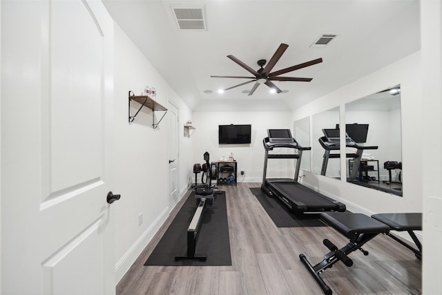 workout area featuring wood finished floors, a ceiling fan, and baseboards