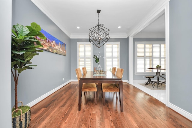 dining space featuring crown molding, baseboards, wood finished floors, and a chandelier