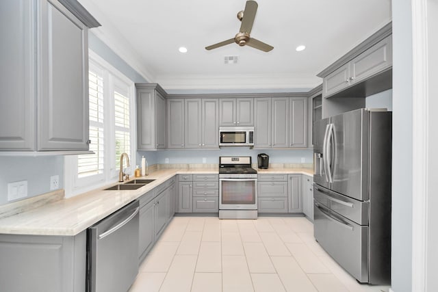 kitchen with crown molding, a sink, gray cabinets, a ceiling fan, and appliances with stainless steel finishes