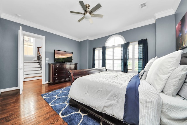 bedroom with visible vents, baseboards, wood finished floors, and multiple windows