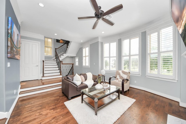 living area featuring crown molding, ceiling fan, baseboards, wood finished floors, and stairway