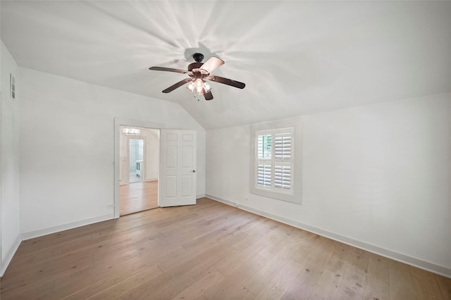 unfurnished bedroom featuring lofted ceiling, light wood finished floors, baseboards, and a ceiling fan