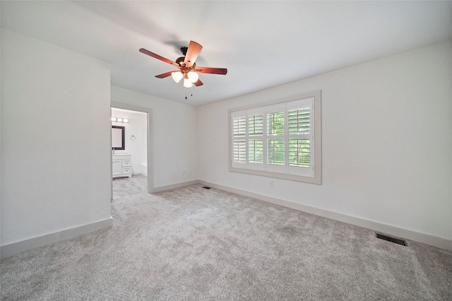 empty room with carpet, visible vents, baseboards, and ceiling fan