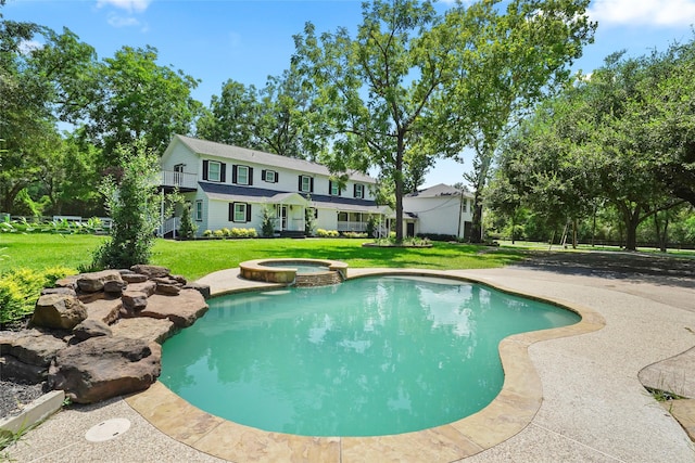 view of swimming pool featuring a lawn and a pool with connected hot tub