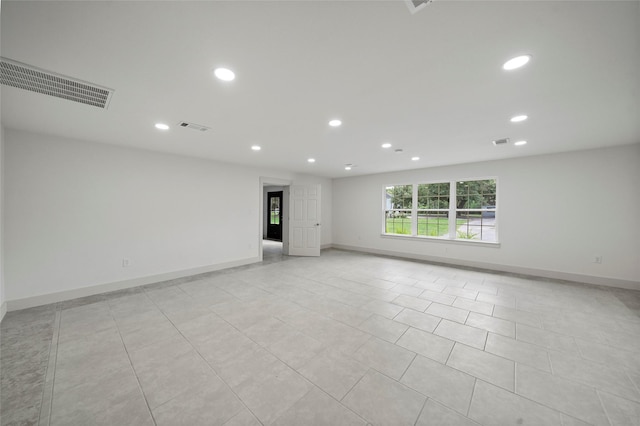 spare room featuring recessed lighting, visible vents, and baseboards