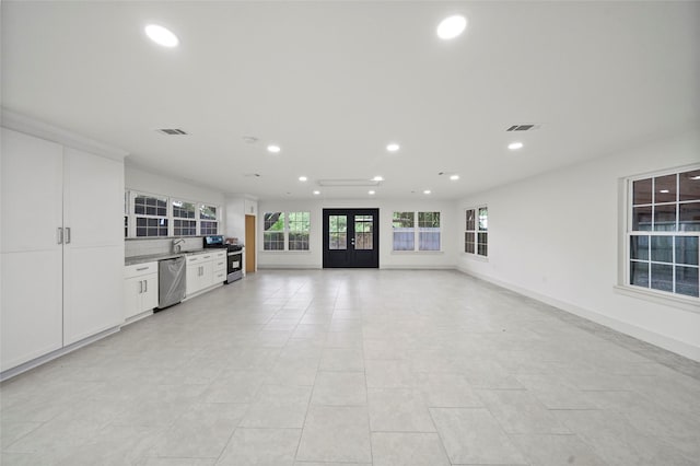 unfurnished living room featuring recessed lighting, visible vents, and baseboards