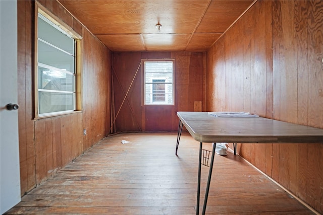unfurnished dining area with hardwood / wood-style floors and wooden walls