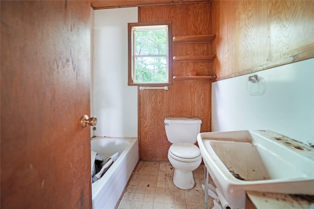 full bathroom featuring a bathtub, toilet, and tile patterned floors