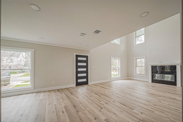 2102 Banks St, Houston, TX 77098 - unfurnished living room featuring light wood finished floors, baseboards, and a healthy amount of sunlight