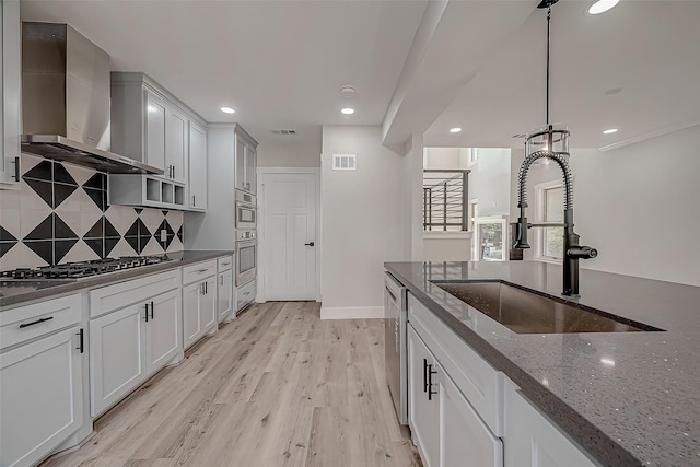 2102 Banks St, Houston, TX 77098 - kitchen featuring visible vents, wall chimney range hood, stainless steel appliances, and a sink