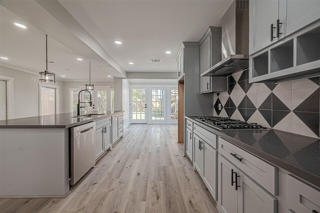 2102 Banks St, Houston, TX 77098 - kitchen with light wood finished floors, wall chimney range hood, french doors, a sink, and appliances with stainless steel finishes
