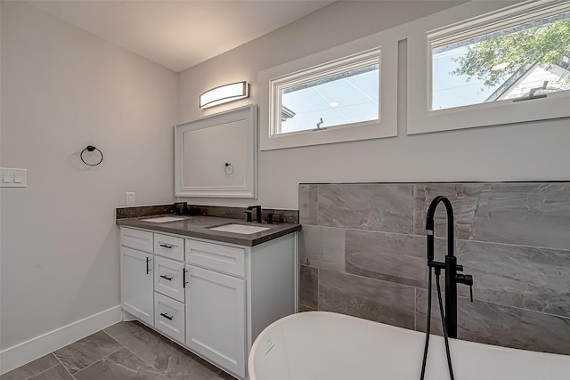 2102 Banks St, Houston, TX 77098 - full bathroom featuring marble finish floor, double vanity, a sink, baseboards, and a soaking tub