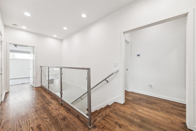 corridor with baseboards, dark wood-style flooring, an upstairs landing, and recessed lighting