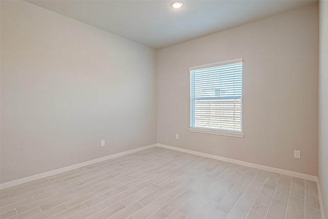 empty room with baseboards, recessed lighting, and light wood-style floors