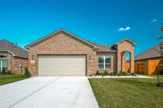 ranch-style home with driveway, fence, brick siding, an attached garage, and a front yard
