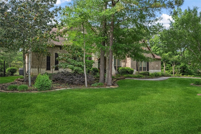 exterior space featuring stone siding, a front yard, and fence