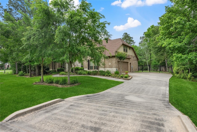 view of front of property featuring concrete driveway, a front lawn, an attached garage, fence, and brick siding