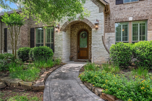 property entrance featuring stone siding and brick siding