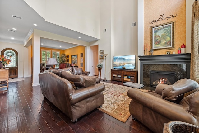 living room with dark wood finished floors, baseboards, visible vents, and a fireplace
